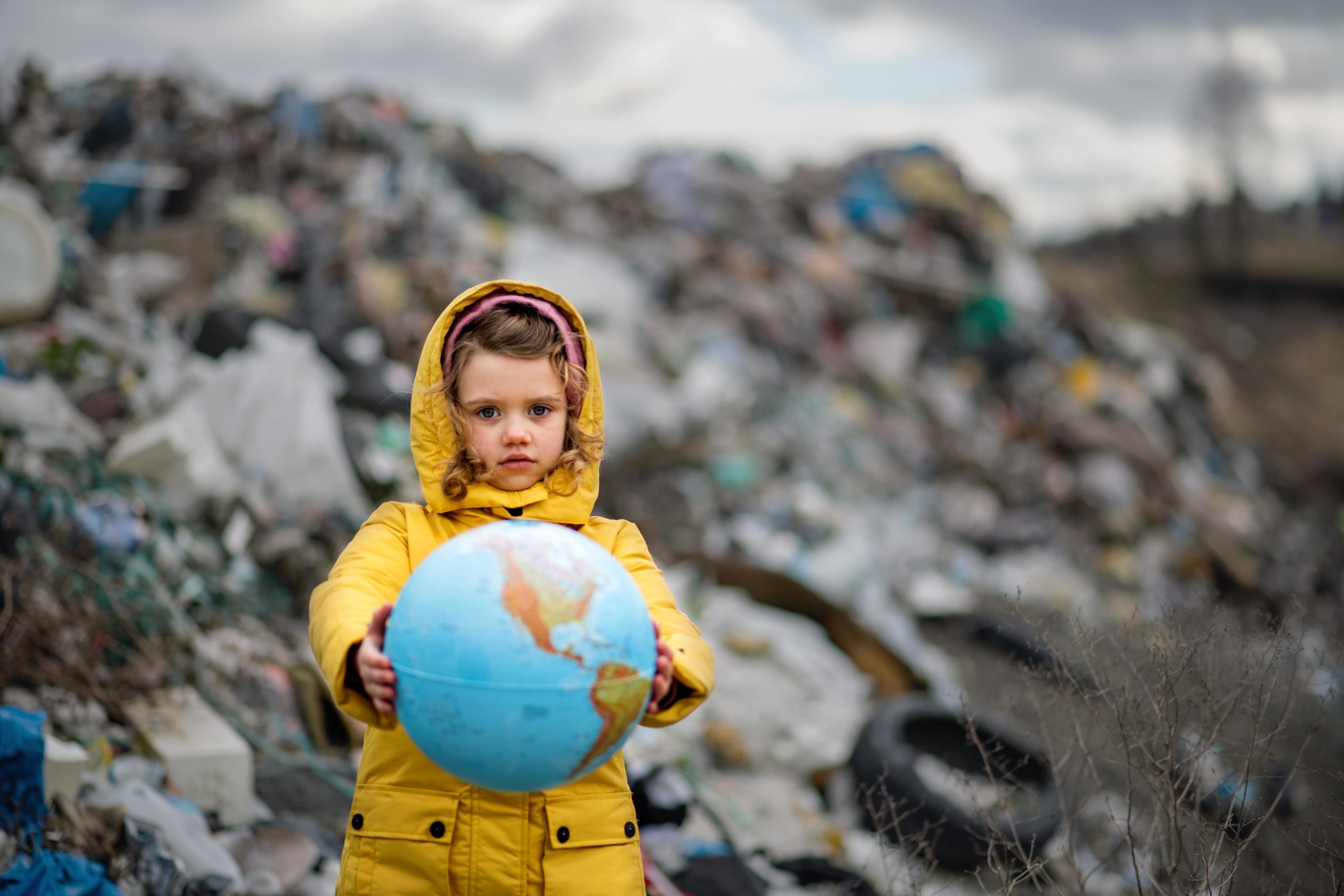 Small Child Holding Globe On Landfill Environment 2021 08 27 18 39 14 Utc Min