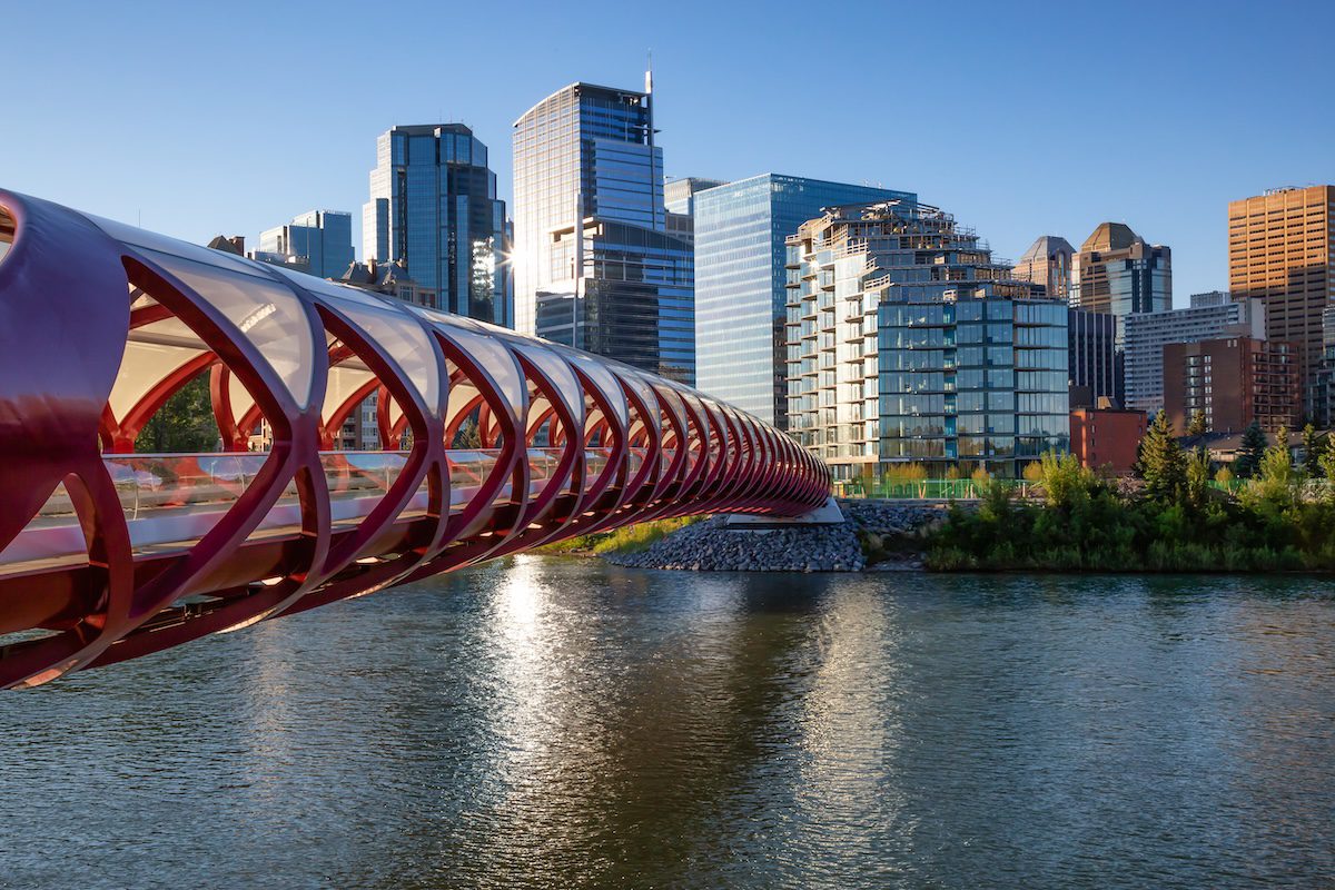 Peace Bridge Across Bow River During A Vibrant Summer Sunrise